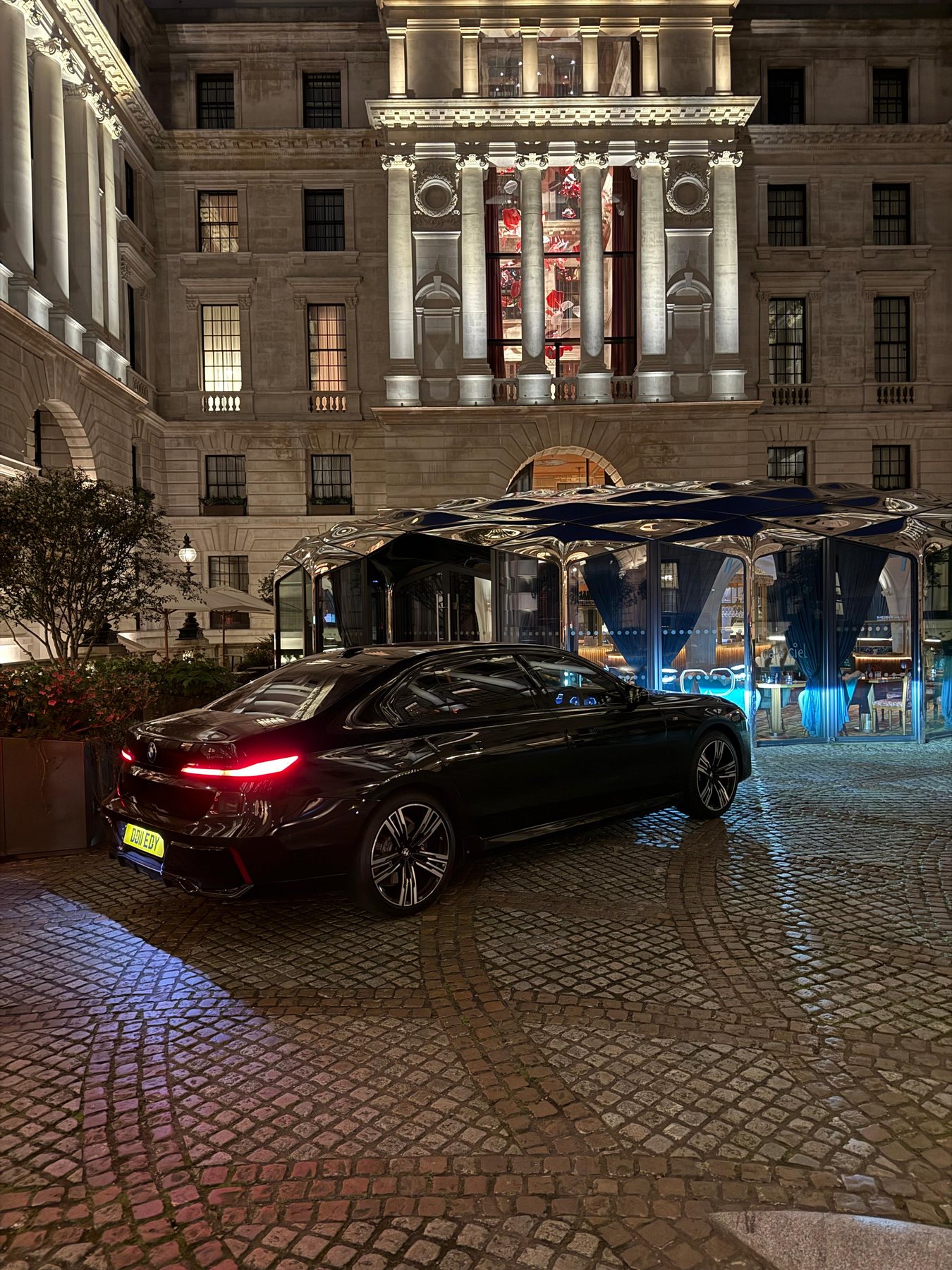 Rear three-quarter view of a Halcolux BMW 7 Series at night